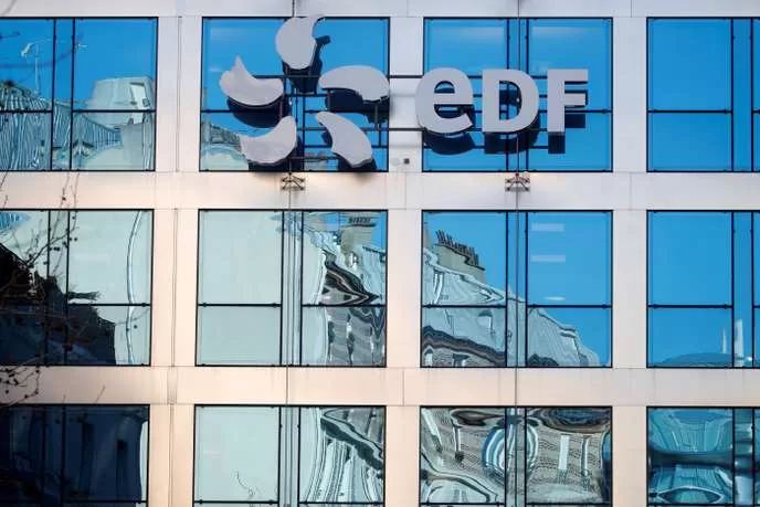 Façade vitrée d’un immeuble de bureaux avec un logo composé d’une hélice et les lettres EDF en haut à droite