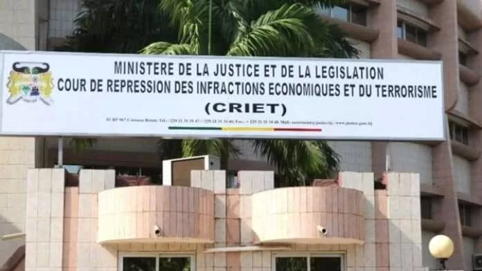 Entrée d’un bâtiment avec une grande enseigne indiquant ministère de la justice et législation, CRIET visible
