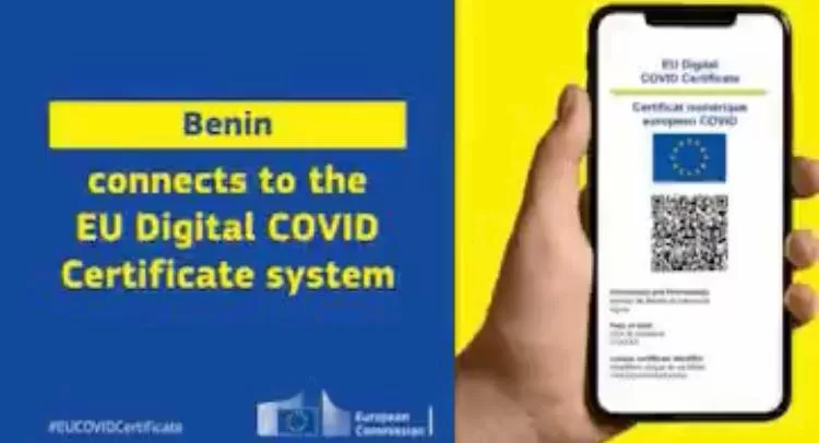 Main tenant un smartphone avec un certificat numérique Covid-19 affiché à côté d’un texte en anglais sur fond bleu et jaune