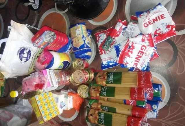 Divers produits alimentaires emballés posés sur un sol carrelé aux motifs circulaires