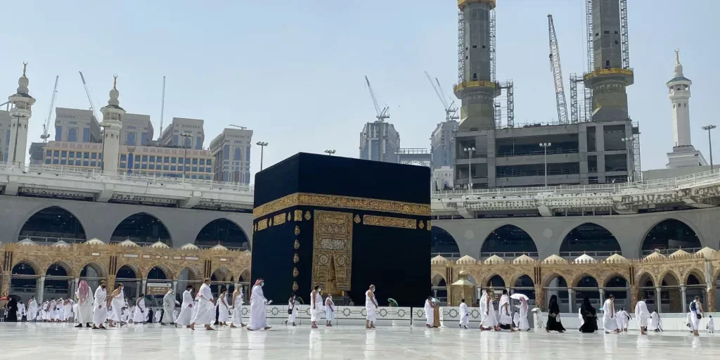 De nombreux pèlerins en tenue blanche accomplissent le tawaf autour de la Kaaba au sein de la grande mosquée.