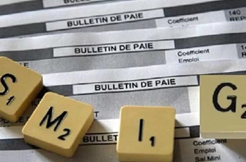 Dés est posé sur des bulletins de paie imprimés avec le texte SMIG écrit en lettres dés