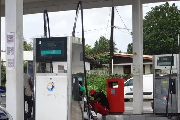 Pompes à essence au repos sous un abri dans une station-service partiellement vide en milieu urbain