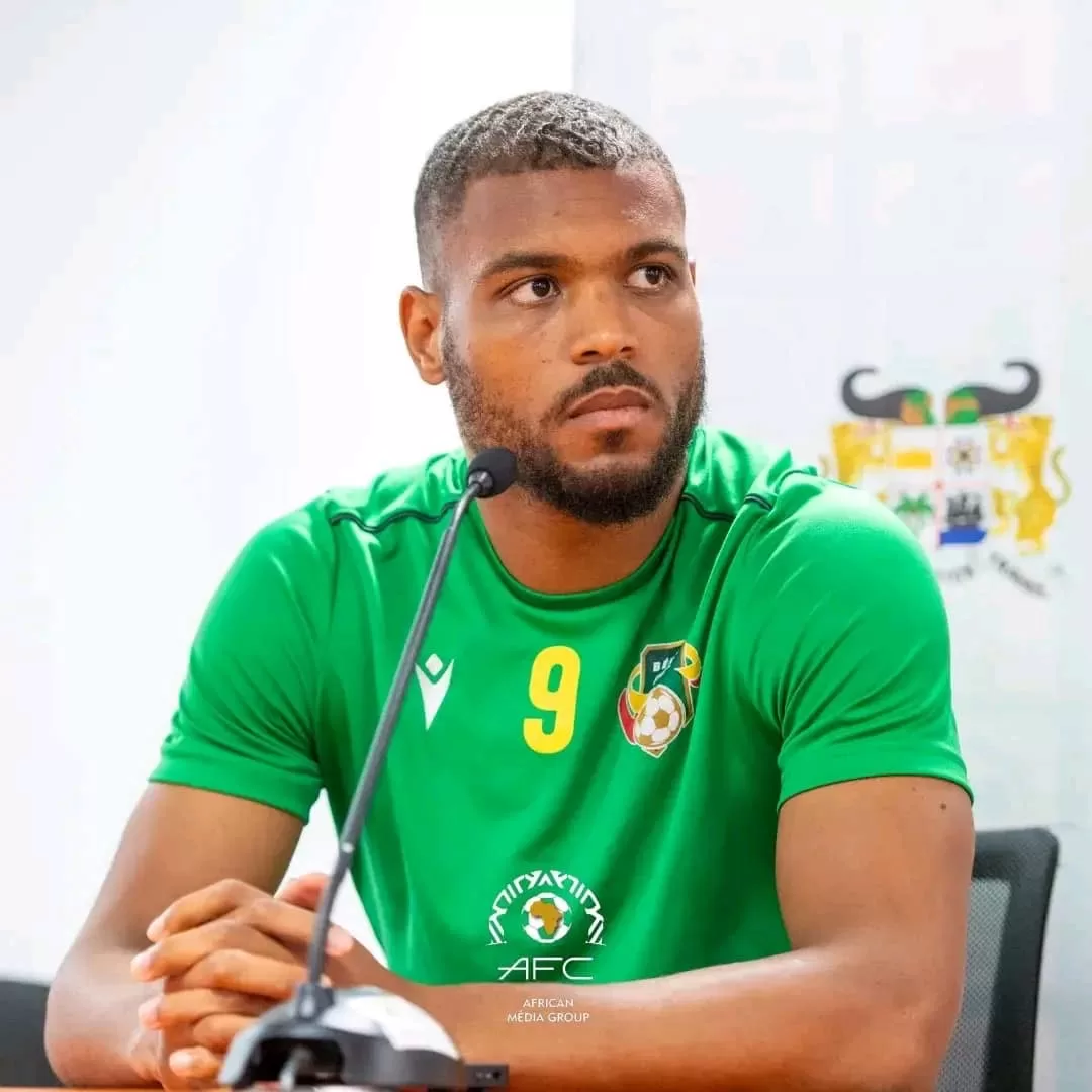 Homme en maillot vert numéro 9 assis devant un micro lors d'une conférence de presse