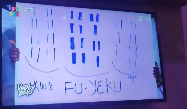 Deux mains tiennent un tableau blanc avec des dessins et les mots KWÈ FU-YÈKU écrits en bleu au centre