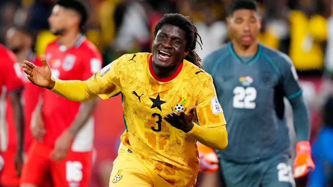 Un joueur en maillot jaune célèbre un but tandis que des adversaires en rouge et un gardien en gris restent en arrière