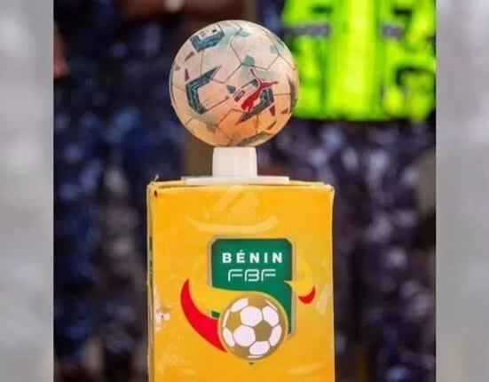 Ballon de football posé sur un socle jaune marqué du logo de la fédération béninoise de football