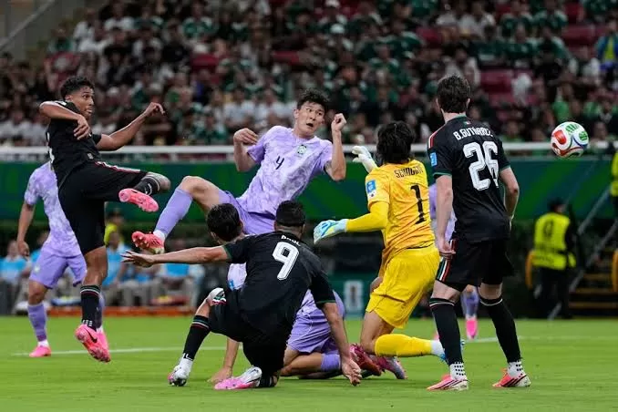 Joueurs de football en action face au but avec un gardien en jaune tentant d’arrêter le ballon lors d’un match intense