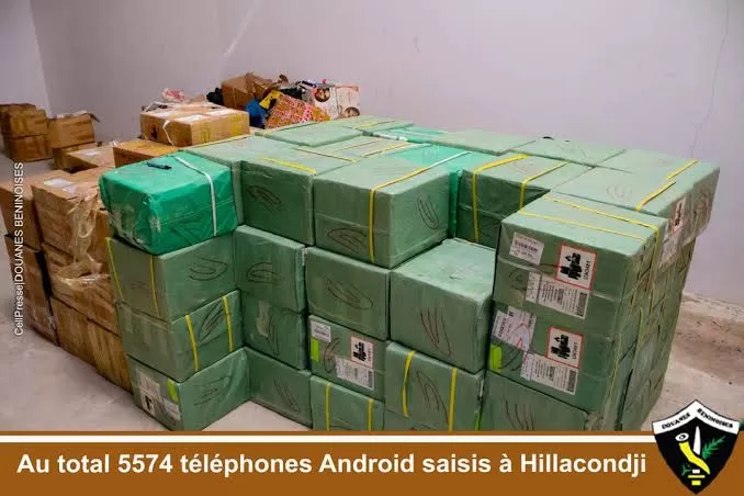 Plusieurs piles de cartons verts et bruns emballés et empilés dans une pièce vide