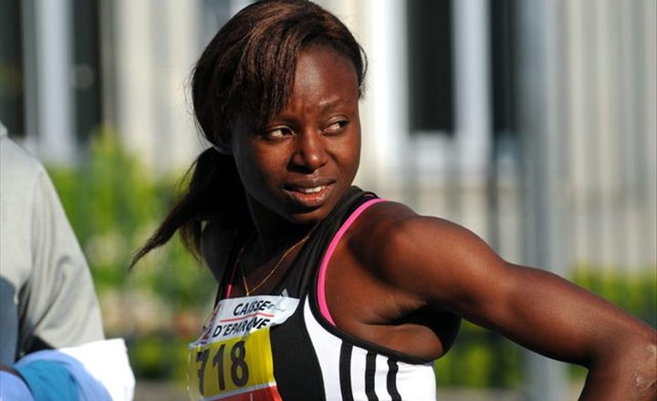 Femme athlète en tenue de compétition regardant sur le côté lors d’un événement sportif en extérieur