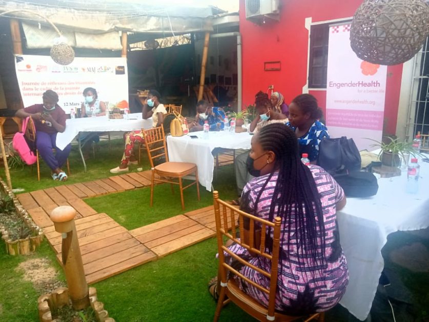 Groupe de femmes assises autour de tables rondes dans un espace extérieur pour une réunion ou un atelier