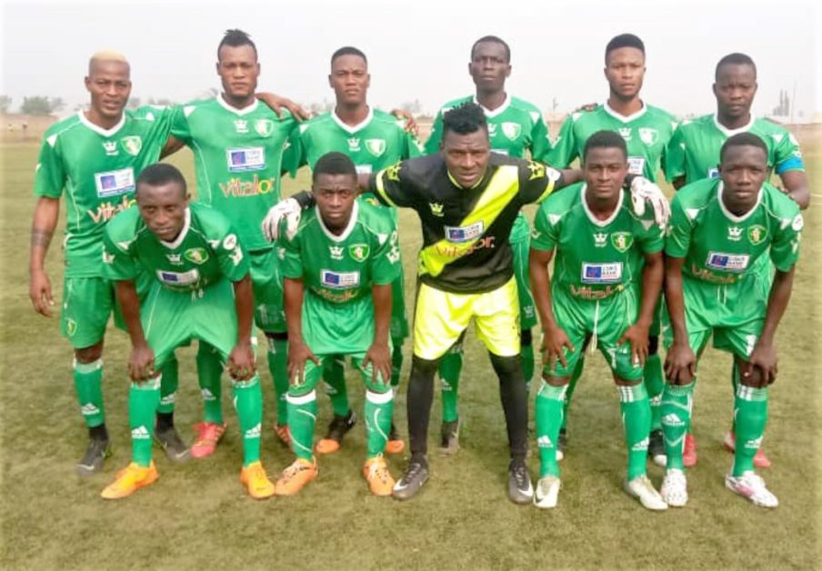 Onze joueurs d une équipe de football posant en formation sur un terrain herbeux