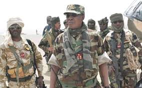Un groupe de militaires en tenue de camouflage marchant dans un environnement désertique sous un ciel clair