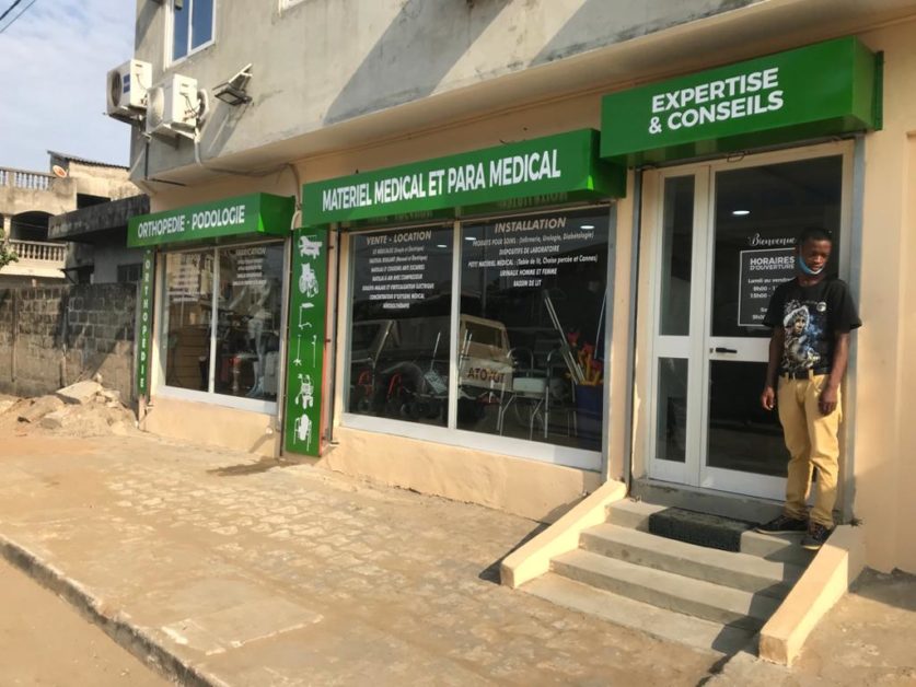 Façade d un magasin avec enseignes vertes pour matériel médical et para médical un homme debout près de l entrée