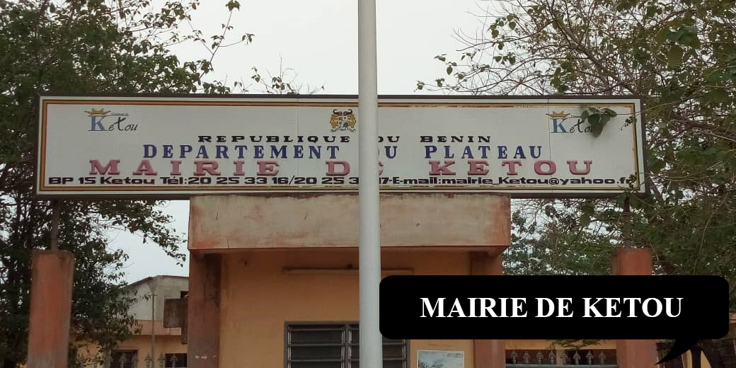 Panneau indiquant le département du Plateau et la mairie de Kétou sur un bâtiment administratif entouré d'arbres