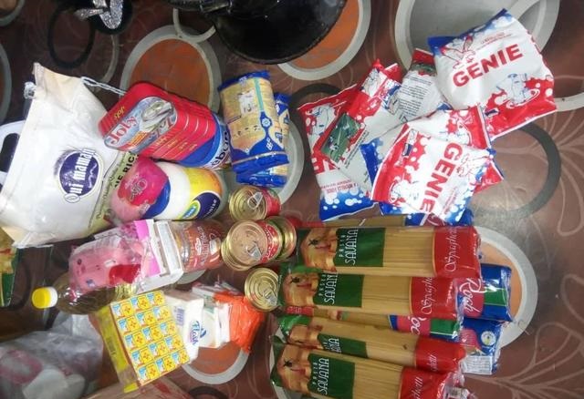 Divers produits alimentaires emballés posés sur un sol carrelé aux motifs circulaires