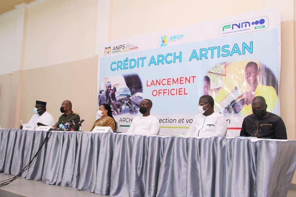 Six personnes assises à une table longue devant une bannière annonçant un lancement officiel portant sur un crédit artisan