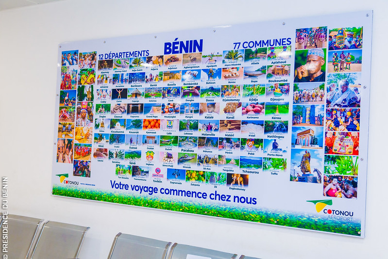 Affiche colorée présentant les 12 départements et 77 communes du Bénin avec nombreuses photos touristiques et texte bleu et vert