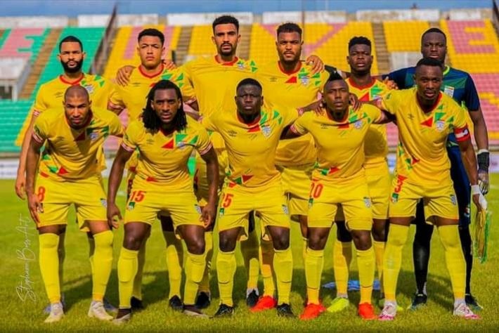 Onze joueurs d une équipe de football en tenue jaune posant sur un terrain avant un match