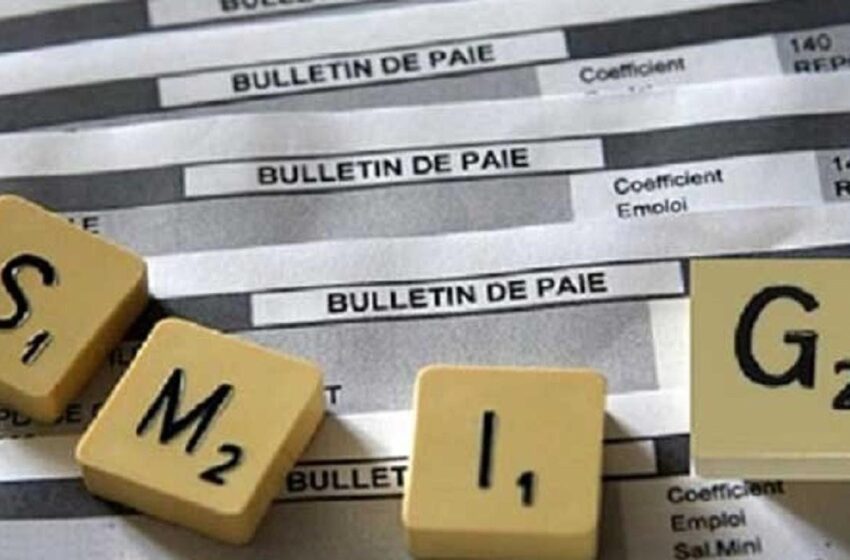 Dés est posé sur des bulletins de paie imprimés avec le texte SMIG écrit en lettres dés