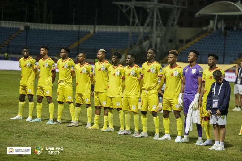 Onze joueurs en tenue jaune alignés sur le terrain avant le début d'un match de football nocturne