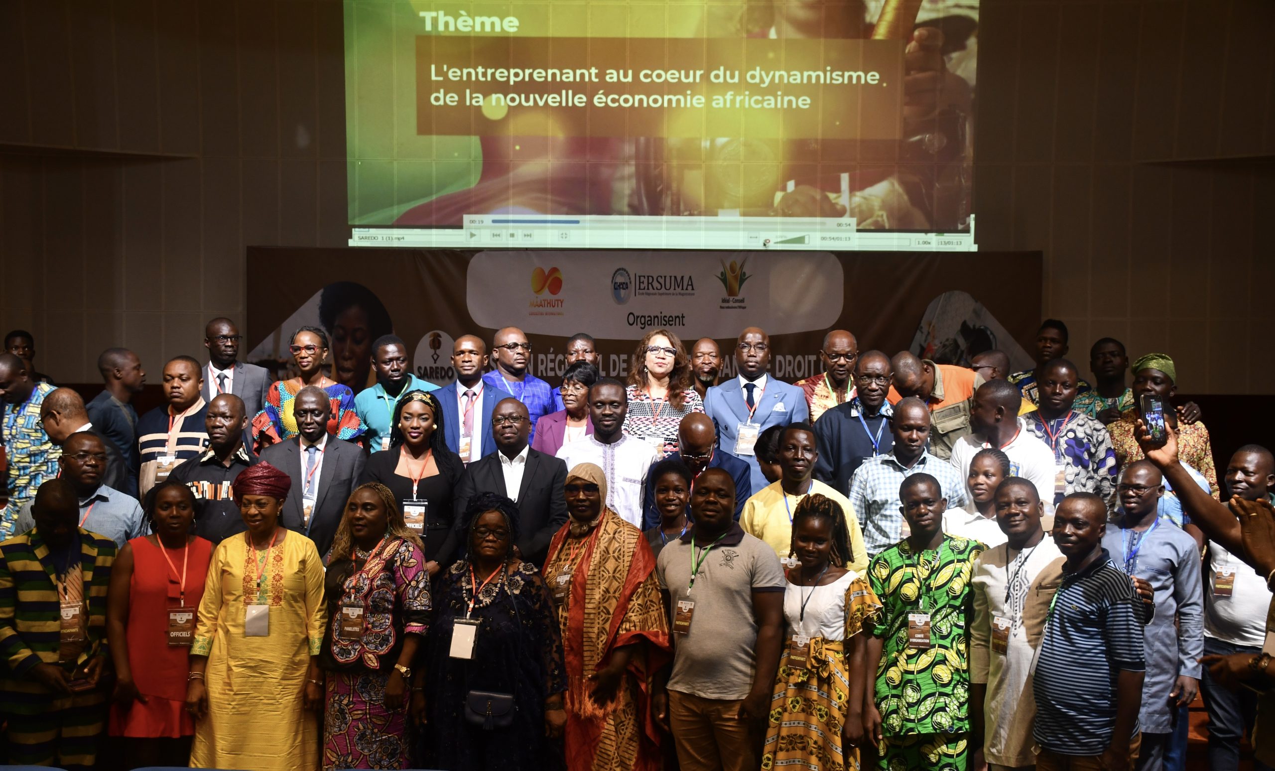 Groupe de personnes posant devant un écran avec un thème sur l’entreprenariat et l’économie africaine