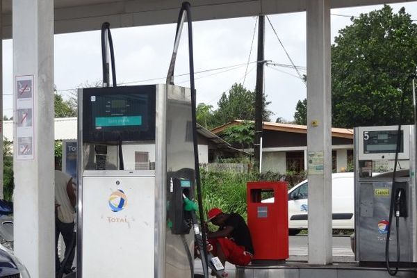 Pompes à essence au repos sous un abri dans une station-service partiellement vide en milieu urbain