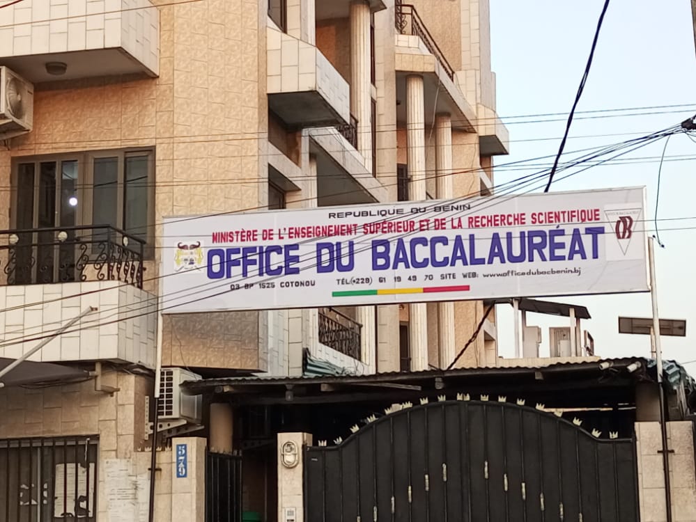 Bannière suspendue au-dessus d'une entrée avec texte officiel concernant l'office du baccalauréat dans un quartier urbain