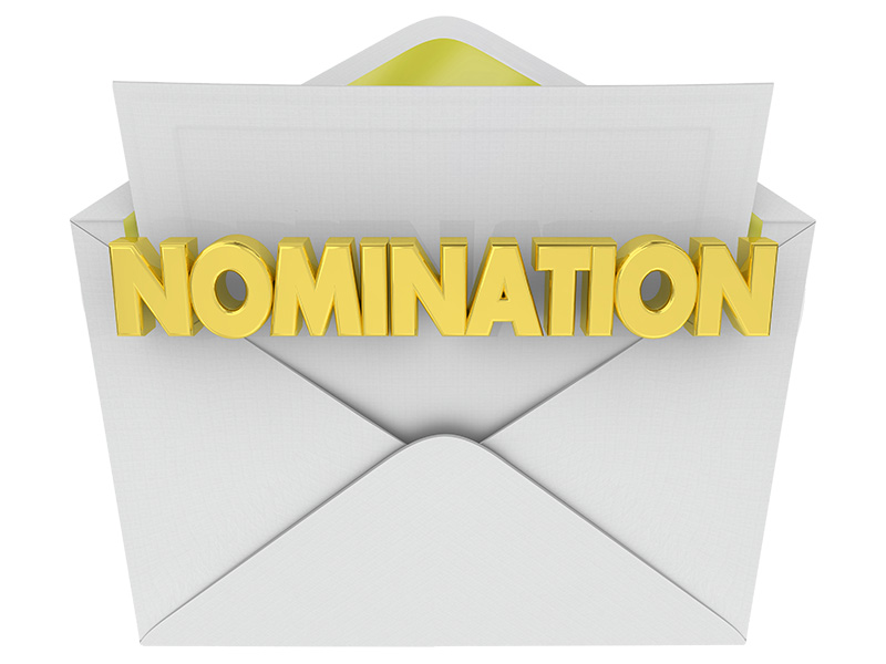 Une enveloppe blanche ouverte contenant le mot nomination en lettres jaunes en relief