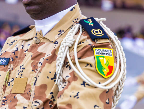 Uniforme camouflage sable d un agent des douanes avec écusson jaune vert et rouge sur l épaule droite