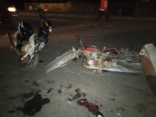 Deux motos renversées au sol la nuit avec des traces de liquide et un gant rouge près des véhicules