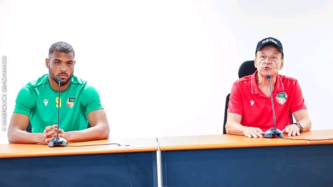 Deux hommes assis à une table face à des microphones lors d une conférence de presse