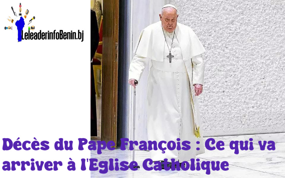 Un homme âgé vêtu d'une robe blanche avec une croix autour du cou s'appuie sur une canne en marchant.