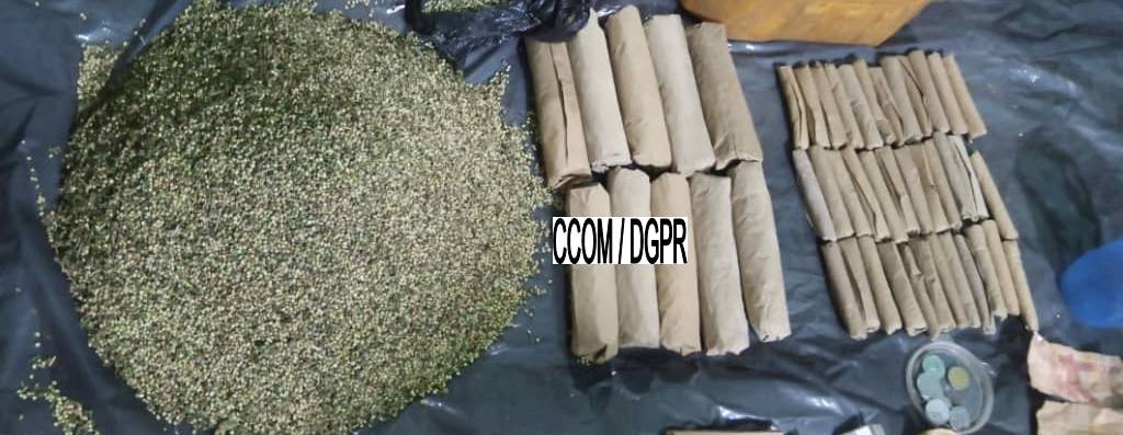 Matière végétale étalée et plusieurs rouleaux emballés posés sur une surface noire avec inscription CCOM/DGPR