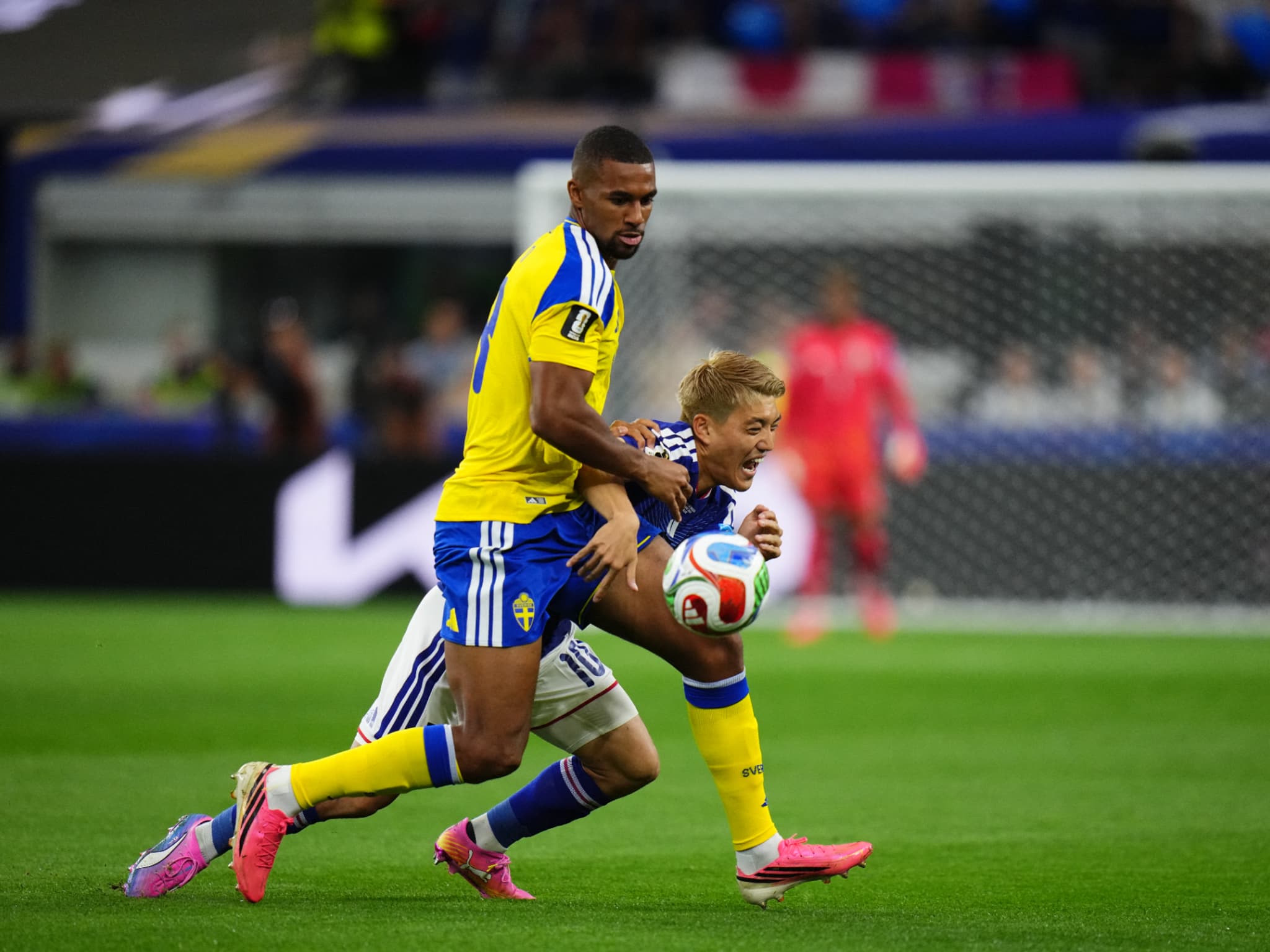 Deux joueurs en maillot jaune et bleu disputent le ballon lors d’un match de football en plein stade