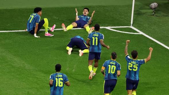 Joueurs de football en maillots bleus et jaunes célébrant un but sur un terrain vert près du coin du terrain