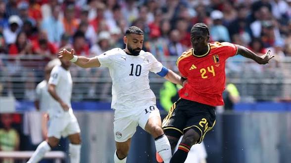 Deux joueurs de football s affrontent lors d un match devant un public nombreux dans un stade en plein jour